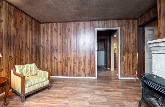 livingroom, doorway to kitchen, paneling walls, laminate flooring