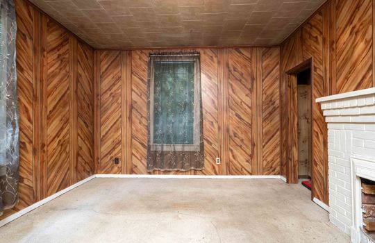 bedroom, carpet, brick fireplace, paneling walls