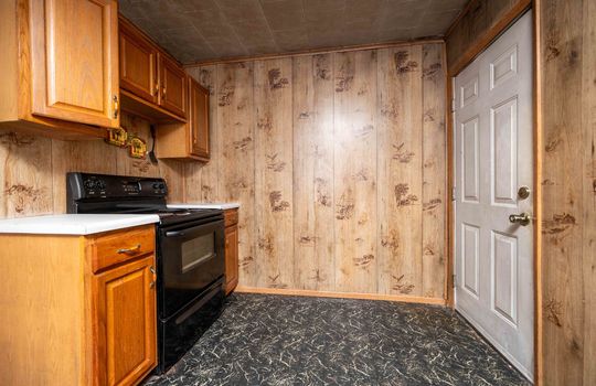 kitchen, laminate flooring, range/oven, paneling walls, cabinets, countertops