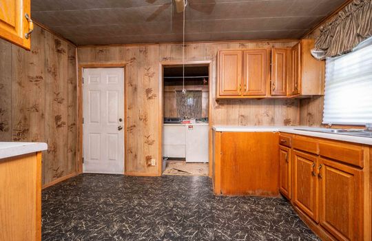 kitchen, cabinets, countertops, exterior door, laundry area, vinyl flooring, sink, window above sink