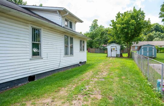 side of home, cottage, vinyl siding, driveway, outbuilding