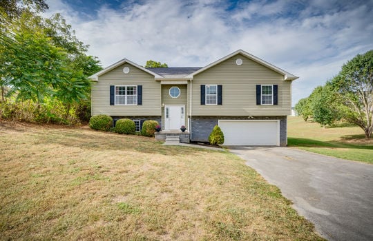 split foyer, vinyl siding, front door, front yard, driveway, garage door, windows, trees, landscaping