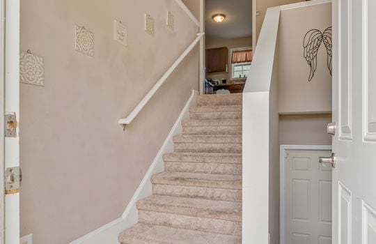 foyer stairs to main level, stairs to basement level, carpeted stairs, hand rails