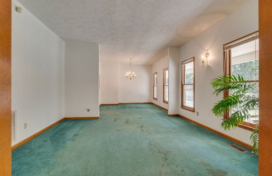 formal living room, formal dining area, carpet, chandelier, windows