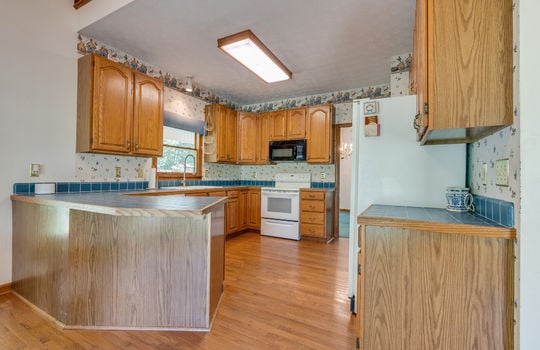 kitchen, hardwood flooring, cabinets, island, countertops, microwave, oven/range, refrigerator, sink