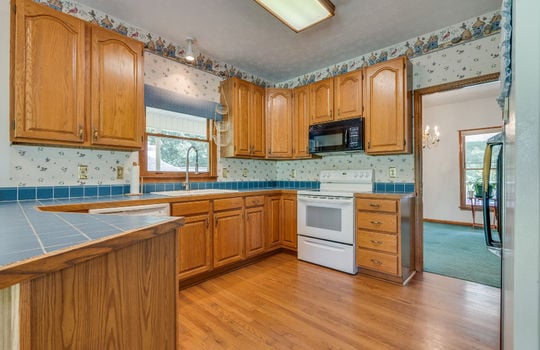 kitchen, hardwood flooring, cabinets, island, countertops, microwave, oven/range, refrigerator, sink