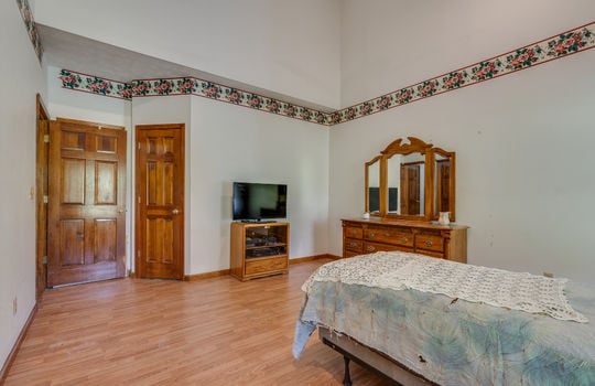 main level primary bedroom, bedroom, vaulted ceiling, recessed lighting, hardwood flooring, windows