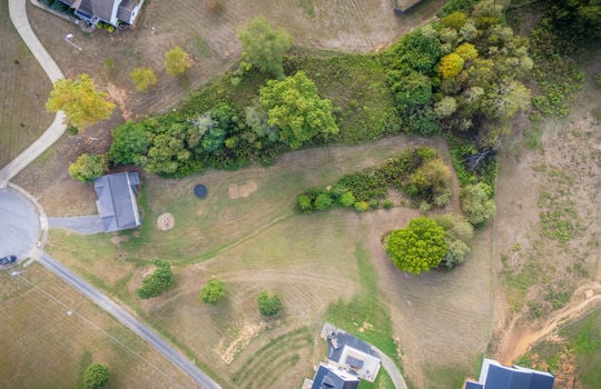 aerial view over home and property, split level home, front yard, back yard, driveway, trees, back yard