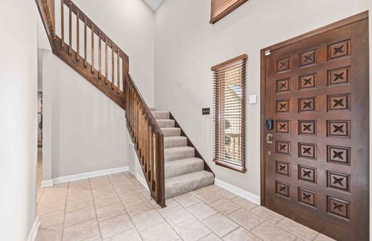 front door, tile foyer, stairs, carpeted stairs