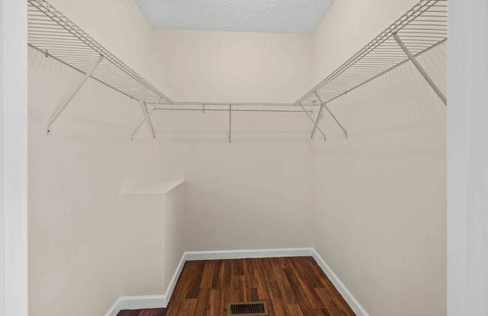 walk in closet, laminate flooring, wire shelving