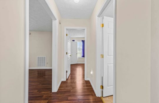 hallway, laminate flooring, doors to bedrooms and bathroom