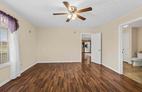 primary bedroom, ceiling fan, laminate flooring, door to ensuite bath