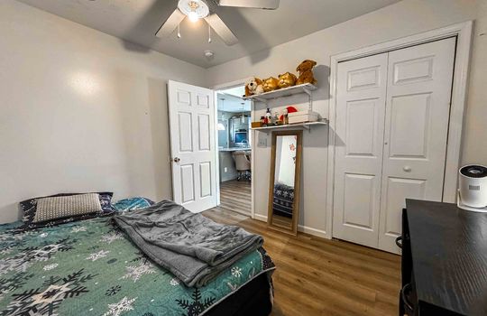 second bedroom, luxury vinyl flooring, door to living room, closet, ceiling fan