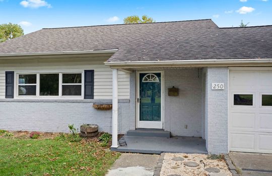 covered front porch, front door, windows, house, cottage, brick, vinyl siding, garage door, sidewalk