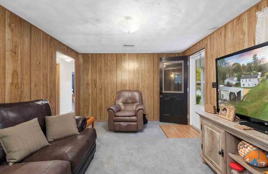 living room, carpet, paneling walls, front door