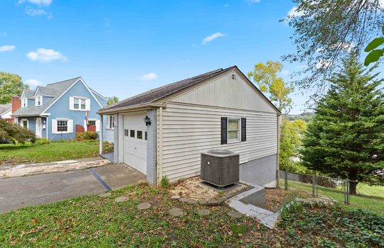 side view of home, cottage, garage, garage door, heat pump, steps to back yard