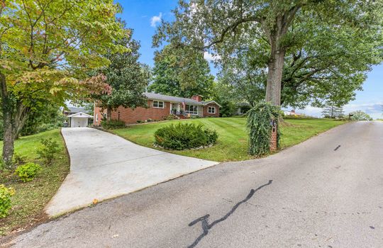 road, driveway, concrete driveway, brick, ranch, yard, front yard, landscaping, trees