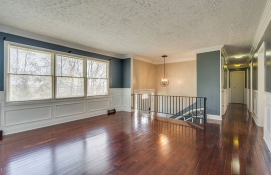 living room, hardwood flooring, wainscoting, hallway, stair railing