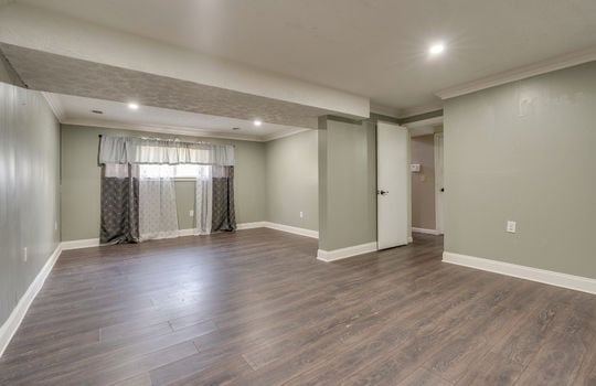 lower level living area, recessed lighting, window, bathroom door