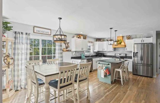 open dining space view into kitchen, laminate flooring, kitchen island, french door to back deck