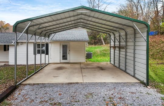 covered carport, gravel driveway, front door