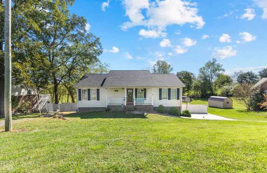 ranch style home, covered front porch, front yard, driveway, trees