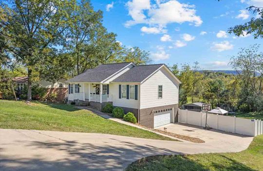 driveway view, ranch style home, driveway, drive under garage, covered front porch, fencing