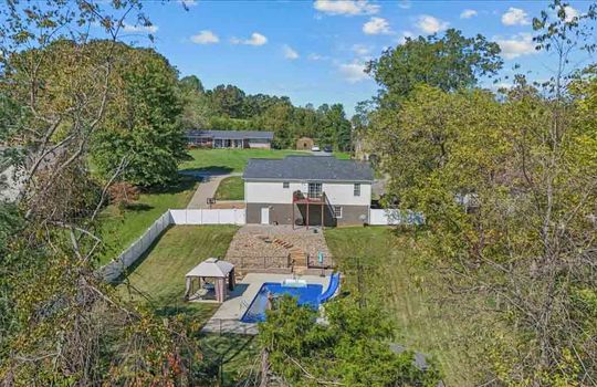 aerial view of back yard, pool, back deck, back of home, fencing, trees