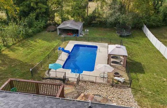 aerial view of back yard, back deck, landscaping, stone landscaping, swimming pool, pergola, firepit, carport, fencing