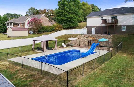 back yard view toward back of home, swimming pool, fencing, pergola, firepit, back deck, back of home, vinyl siding, patio