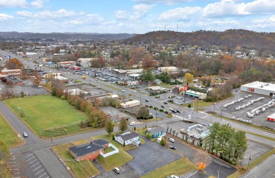 aerial photo of property, front view of property, front yard, back parking lot, neighboring homes & businesses, roads, mountain views