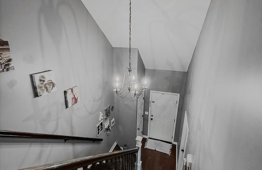 upper level view toward foyer, chandelier, stairs, front door