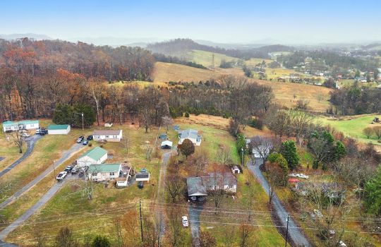 Aerial photo of property and neighboring homes, trees, mountain views