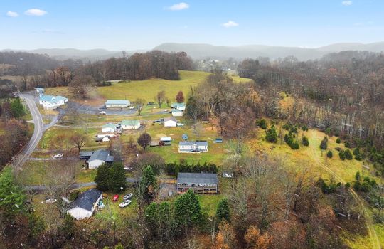 Aerial photo of property and neighboring homes, trees, mountain views