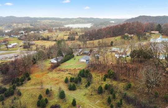 Aerial photo of property and neighboring homes, trees, mountain views