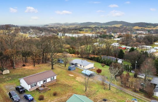 Aerial photo of property and neighboring homes, trees, mountain views