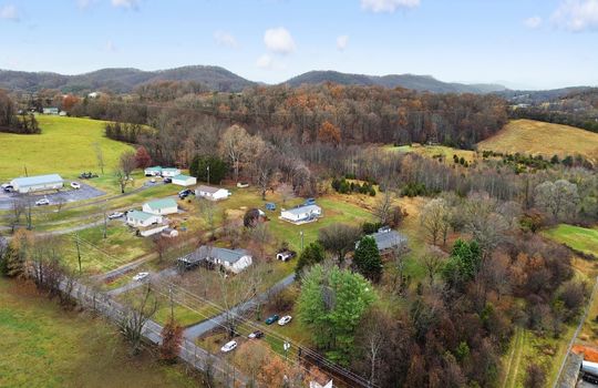 Aerial photo of property and neighboring homes, trees, mountain views