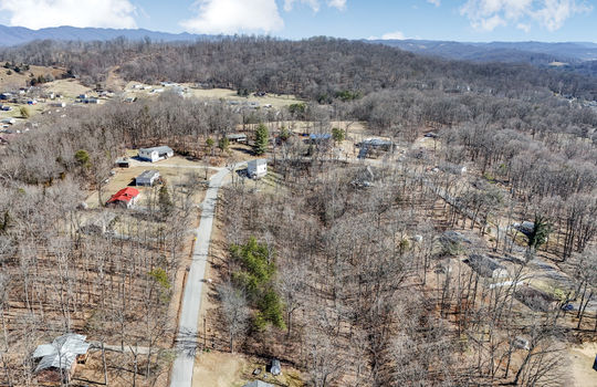 aerial view of land, neighboring properties, mountain views, road,