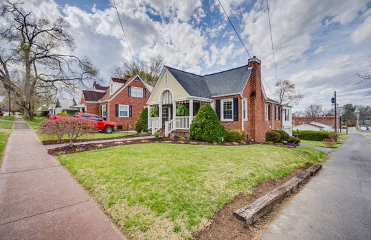 right front view of home, brick, traditional style home, covered front porch, landscaping, driveway, sidewalk