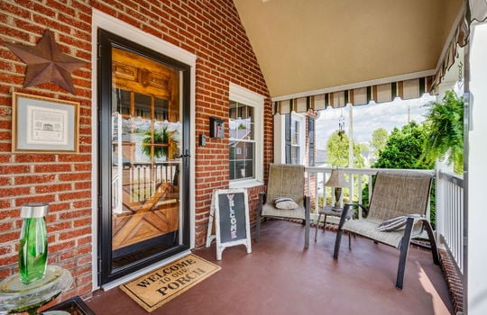 front porch, covered front porch, front door, storm door, brick exterior, concrete porch
