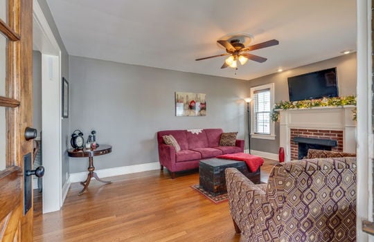 living room, hardwood flooring, ceiling fan, fireplace, windows
