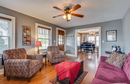 living room, front door, windows, ceiling fan, hardwood flooring, doorway to formal dining room