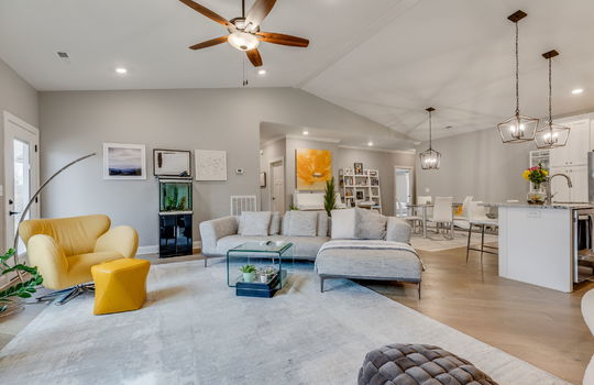 Open floorplan, living room, vaulted ceiling, ceiling fan, luxury vinyl flooring, dining space, kitchen, kitchen island