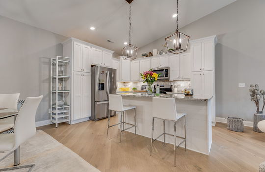 kitchen, kitchen island, granite countertops, cabinets, oven/range, refrigerator, built in microwave, cabinets, luxury vinyl flooring, recessed lighting