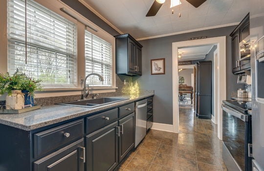 kitchen, stone counters, cabinets, stainless appliances, built in microwave, oven/range, refrigerator, dishwasher,tile flooring, ceiling fan, sink, window above sink