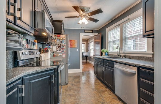 kitchen, stone counters, cabinets, stainless appliances, built in microwave, oven/range, refrigerator, dishwasher, tile flooring, ceiling fan, sink, window above sink