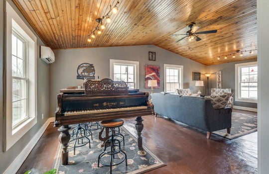 vaulted ceiling den/bedroom, windows, ceiling fan, concrete flooring