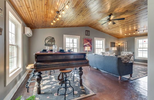 vaulted ceiling den/bedroom, ceiling fan, light fixtures, concrete flooring