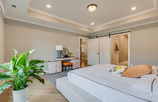 bedroom, tray ceilings, recessed lighting, luxury vinyl flooring, barn door to ensuite bath, door to hallway