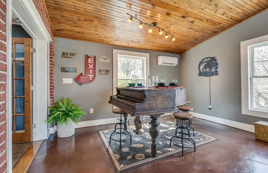 vaulted ceiling, den/bedroom, light fixtures, windows, concrete flooring, french doors
